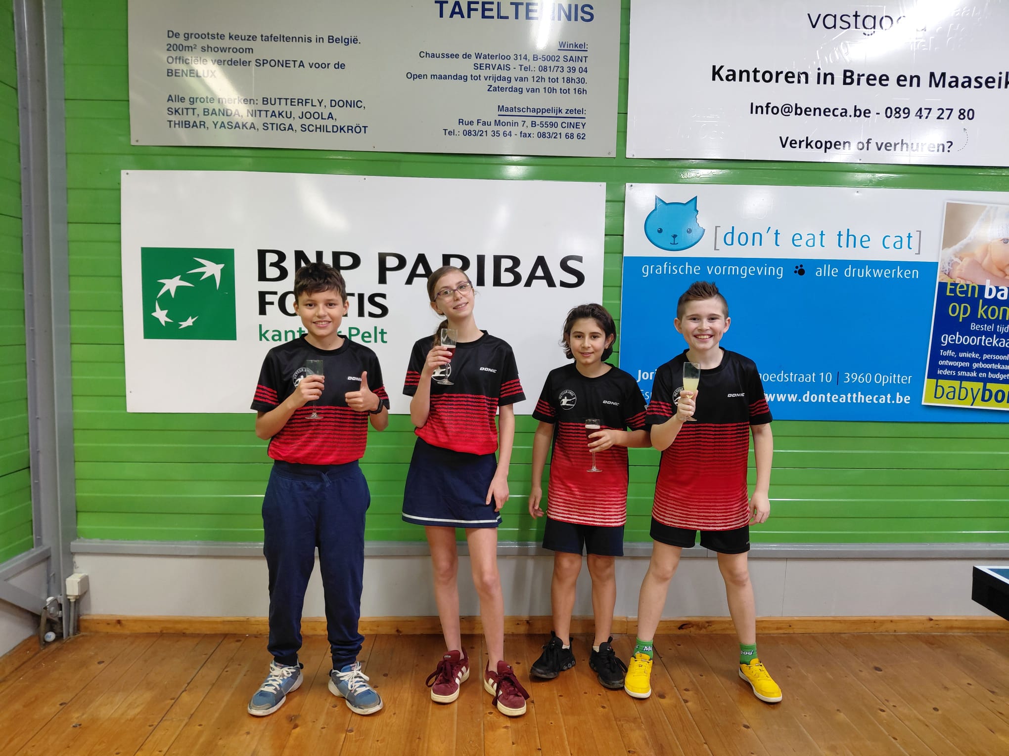 Vier clubleden met bekers in de sportzaal